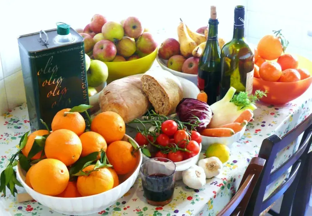 Mediterranean diet ingredients: olive oil, fruits, vegetables, bread, and wine.